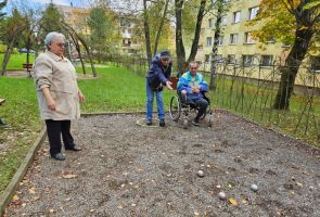 Powiększ zdjęcie: trzy osoby na bulodromie, jedna rzuca bulą