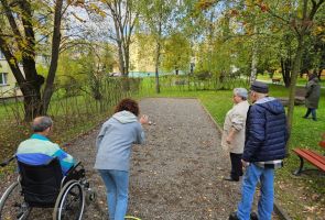 Powiększ zdjęcie: widok na bulodrom, na pierwszym planie cztery osoby tyłem grający w boule