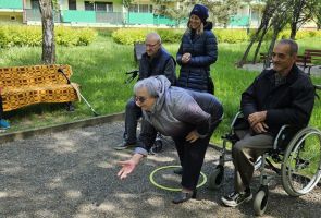 Powiększ zdjęcie: kobieta rzucająca boulą, obok mężczyzna na wózku 