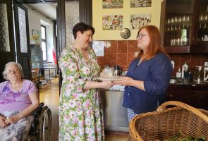 Powiększ zdjęcie: pani dyrektor wręcza zielarce upominek