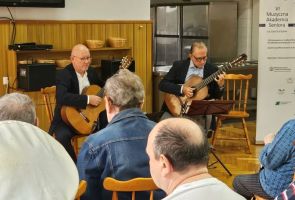 Powiększ zdjęcie: widok na grających na gitarach mężczyzn zza publiczności