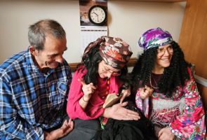 Powiększ zdjęcie: dwie kobiety w strojach Cyganek wróżą z ręki mężczyźnie