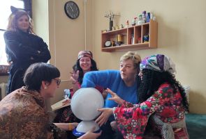 Powiększ zdjęcie: grupa osób w strojach Cyganów wróży ze szklanej kuli