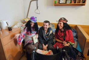 Powiększ zdjęcie: dwie kobiety w strojach Cyganek siedzą z mężczyzną