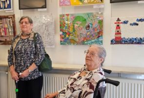 Powiększ zdjęcie: autorki prac na tle wystawy