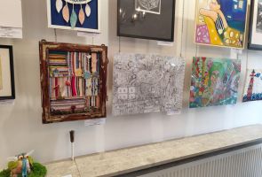 Powiększ zdjęcie: prace wiszące na ścianie podczas wystawy