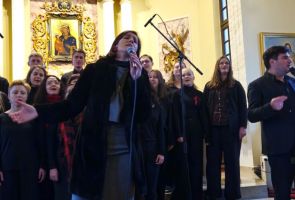 Powiększ zdjęcie: chór i solistka podczas występu