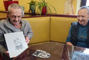 Powiększ zdjęcie: mężczyzna pokazujący swoją odbitkę, obok uśmiechająca się kobieta