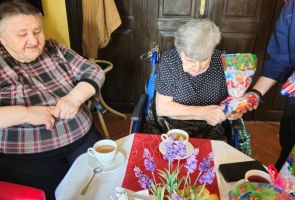 Powiększ zdjęcie: uczennica wręczająca upominek Mieszkance dps