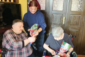 Powiększ zdjęcie: uczennica wręczająca upominek Mieszkance dps