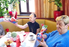 Powiększ zdjęcie: uczennica wręczająca upominek Mieszkance dps