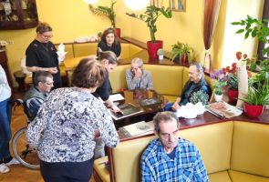 Powiększ zdjęcie: uczestnicy warsztatów obserwujący robienie odbitki linorytu