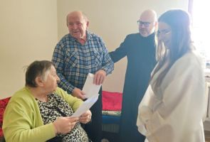 Powiększ zdjęcie: ksiądz składający życzenia kobiecie i mężczyźnie