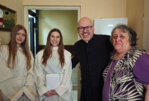 Powiększ zdjęcie: Mieszkanka dps, ksiądz i dwie dziewczyny w stroju aniołów