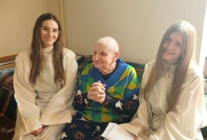 Powiększ zdjęcie: starszy mężczyzna w towarzystwie dwóch dziewczyn w strojach aniołów