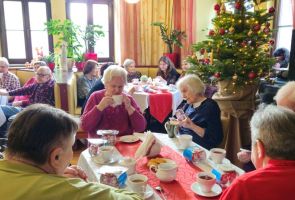 Powiększ zdjęcie: nasi Mieszkańcy siedzący przy stolikach w kawiarni dps