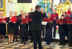 Powiększ zdjęcie: dyrygent i chór podczas koncertu