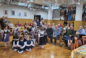 Powiększ zdjęcie: dziewczynki tańczące wokół chłopców siedzących w kółku