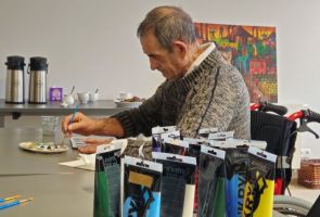 Powiększ zdjęcie: mężczyzna podczas warsztatów malujący na szkle