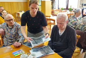 Powiększ zdjęcie: prowadząca rozdaje fotografie do warsztatów