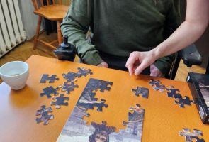 Powiększ zdjęcie: zbliżenie dłoni kilku osób podczas układania puzzli