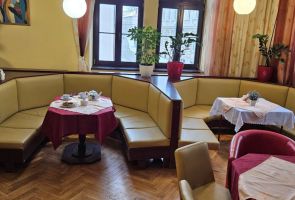 Powiększ zdjęcie: widok wnętrza kawiarni w starym wystroju - stoliki w boksy z kanapami