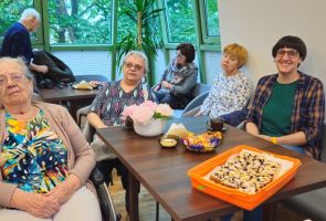 Powiększ zdjęcie: seniorzy przy stoliku podczas spotkania