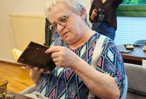 Powiększ zdjęcie: kobieta oglądająca starą książkę
