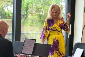 Powiększ zdjęcie: kobieta śpiewająca i mężczyzna grający na instrumencie klawiszowym 