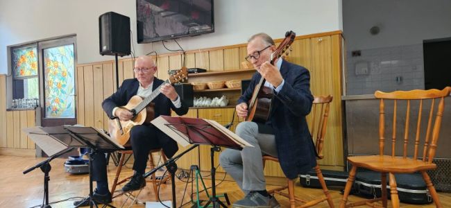 Powiększ zdjęcie: dwóch mężczyzn grających na gitarach